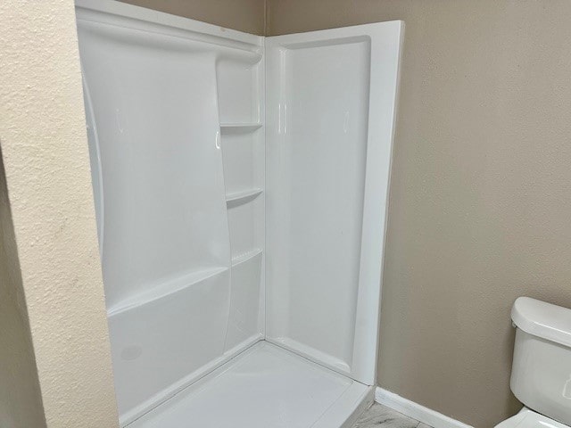 8230 Woodward St, Houston, TX 77051 - bathroom featuring toilet, a stall shower, and baseboards