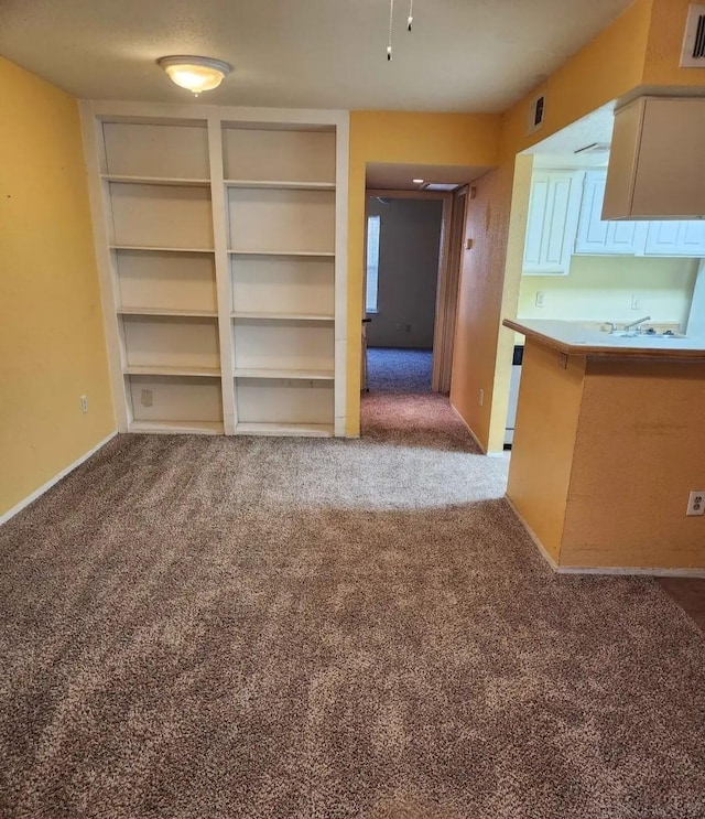 unfurnished dining area featuring carpet floors, visible vents, and baseboards