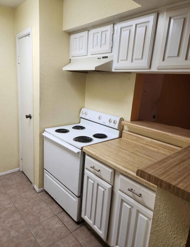 kitchen with white electric range oven, under cabinet range hood, light tile patterned flooring, and white cabinetry