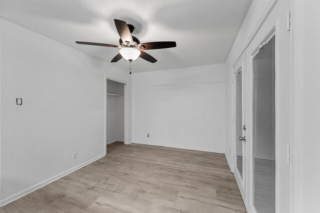 unfurnished bedroom featuring ceiling fan, baseboards, and light wood-style flooring