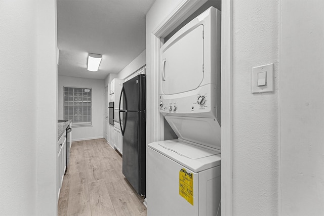 11887 Algonquin Dr, Houston, TX 77089 - laundry room with stacked washer / dryer and light wood finished floors