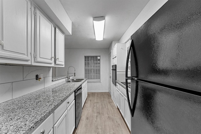 11887 Algonquin Dr, Houston, TX 77089 - kitchen with black appliances, a sink, light wood-type flooring, and white cabinets
