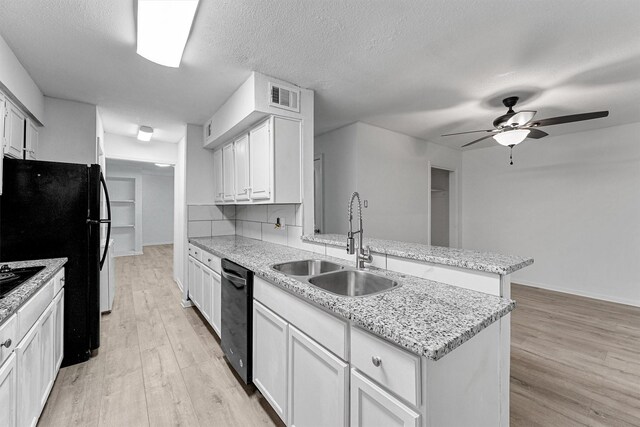 kitchen with a ceiling fan, a sink, light wood-type flooring, a peninsula, and visible vents