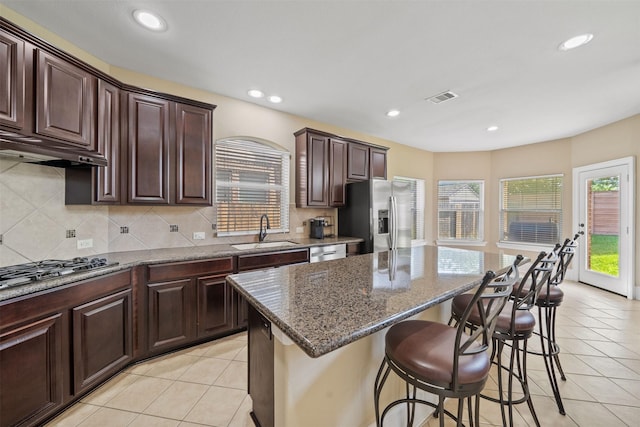 514 Whitney Oaks Ln, Stafford, TX 77477 - kitchen with stainless steel appliances, visible vents, a sink, a center island, and a kitchen bar