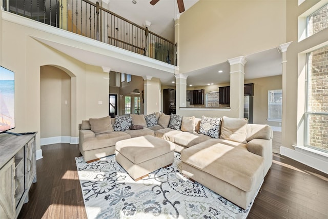 514 Whitney Oaks Ln, Stafford, TX 77477 - living room featuring dark wood finished floors, a high ceiling, baseboards, decorative columns, and ceiling fan