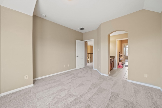 514 Whitney Oaks Ln, Stafford, TX 77477 - unfurnished bedroom with arched walkways, vaulted ceiling, baseboards, visible vents, and light colored carpet