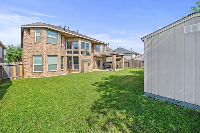 514 Whitney Oaks Ln, Stafford, TX 77477 - rear view of house with brick siding, a yard, and a fenced backyard