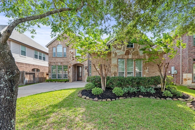 514 Whitney Oaks Ln, Stafford, TX 77477 - view of front of house featuring fence, stone siding, brick siding, and a front yard