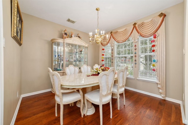 dining room with dark wood finished floors, visible vents, baseboards, and an inviting chandelier