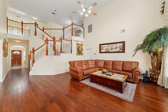 living room featuring a towering ceiling, visible vents, and ceiling fan
