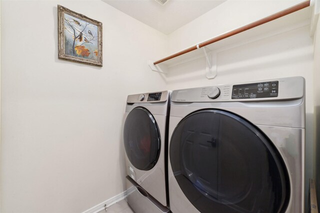 laundry room with separate washer and dryer, baseboards, laundry area, and light tile patterned floors