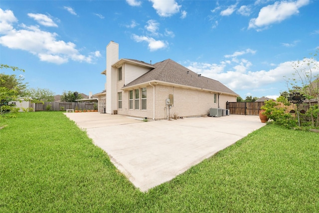back of house featuring a chimney, a fenced backyard, a patio area, a lawn, and roof with shingles