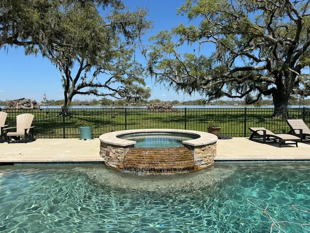view of swimming pool with fence, a patio area, and a pool with connected hot tub