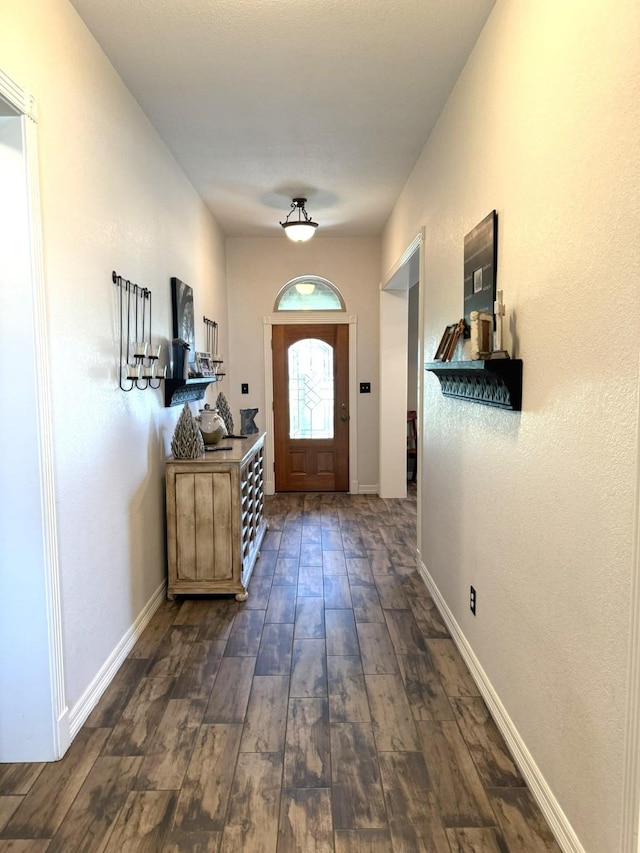 entryway with dark wood-style flooring and baseboards