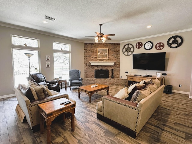 living area featuring a fireplace, a ceiling fan, visible vents, baseboards, and a textured ceiling