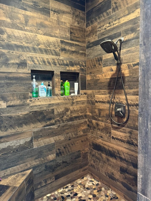 full bath featuring wood walls and a tile shower