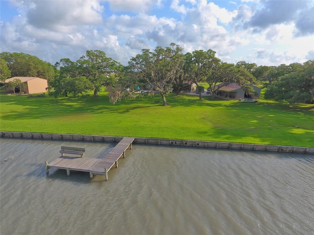 view of home's community featuring a yard, a water view, and a boat dock