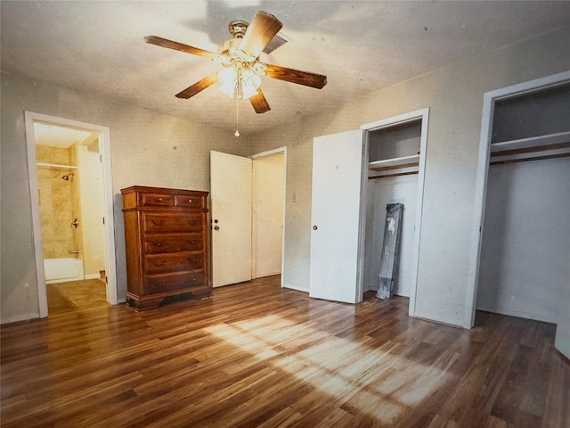 bedroom with a ceiling fan, wood finished floors, connected bathroom, and two closets
