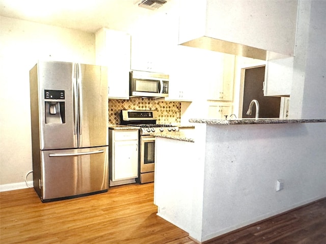 kitchen with white cabinetry, stainless steel appliances, visible vents, and light wood-type flooring