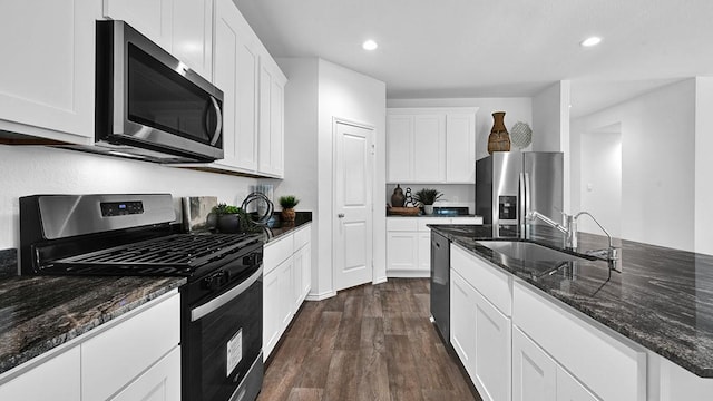 2707 Misty Elm Ln, Rosenberg, TX 77469 - kitchen featuring stainless steel appliances, a sink, recessed lighting, dark stone countertops, and dark wood-style floors