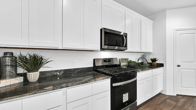 2707 Misty Elm Ln, Rosenberg, TX 77469 - kitchen with appliances with stainless steel finishes, dark wood-style flooring, dark stone counters, and white cabinets