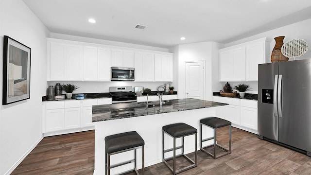 2707 Misty Elm Ln, Rosenberg, TX 77469 - kitchen featuring appliances with stainless steel finishes, a sink, dark wood-style floors, recessed lighting, and a breakfast bar area