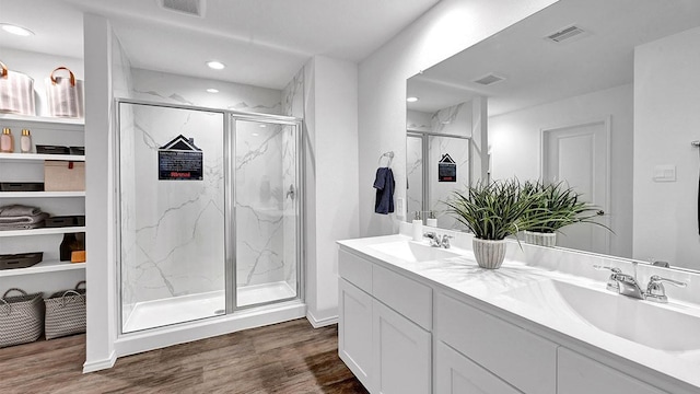 2707 Misty Elm Ln, Rosenberg, TX 77469 - bathroom featuring a marble finish shower, wood finished floors, double vanity, and recessed lighting