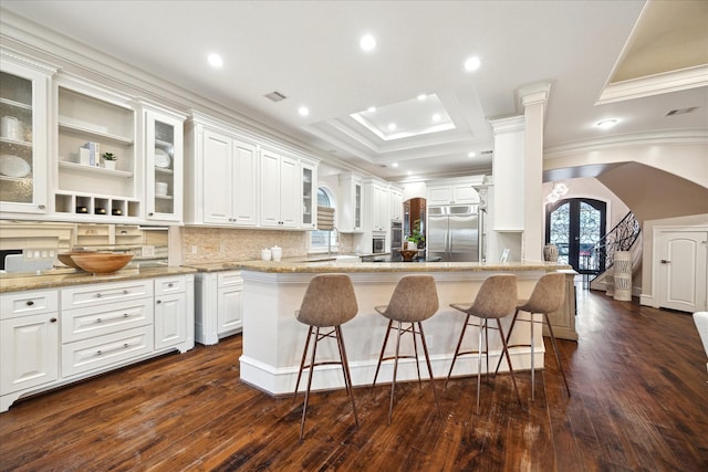 3822 Drummond St, Houston, TX 77025 - kitchen with built in fridge, arched walkways, crown molding, a breakfast bar, and white cabinetry