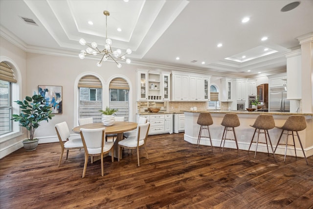 3822 Drummond St, Houston, TX 77025 - dining space featuring a tray ceiling, dark wood-style flooring, a chandelier, crown molding, and recessed lighting