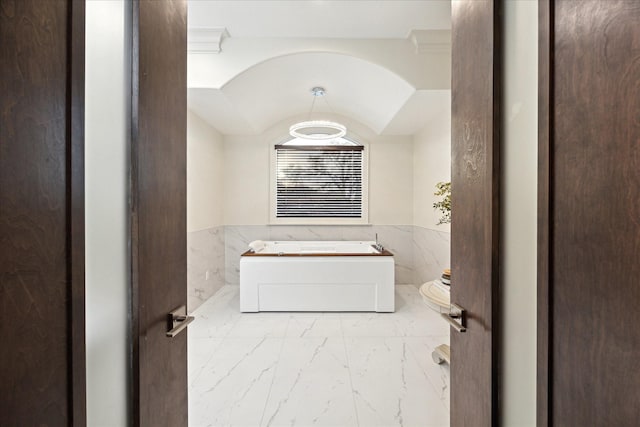 3822 Drummond St, Houston, TX 77025 - full bathroom featuring marble look tiles, tile walls, a bath, a wainscoted wall, and vaulted ceiling