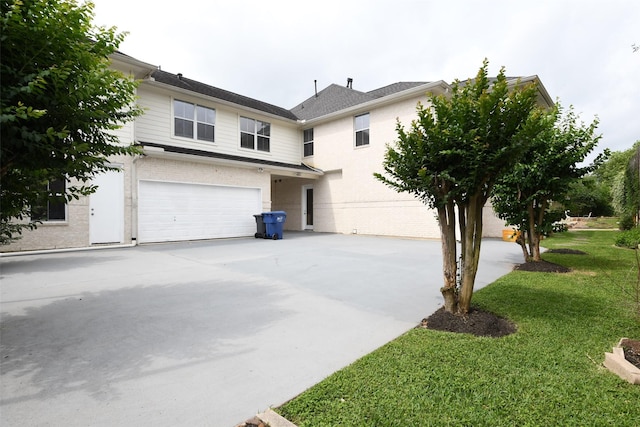 view of front facade with a garage, concrete driveway, a front lawn, and brick siding