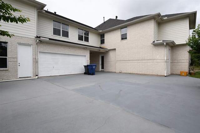 7414 Regency Pl, Spring, TX 77379 - rear view of house with concrete driveway, brick siding, and a garage