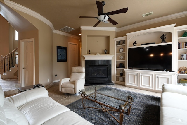 living area featuring crown molding, a ceiling fan, visible vents, and stairway