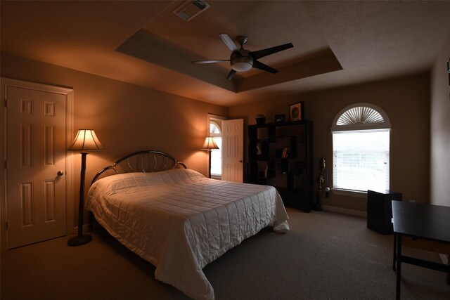 7414 Regency Pl, Spring, TX 77379 - bedroom with carpet flooring, a ceiling fan, baseboards, a tray ceiling, and visible vents