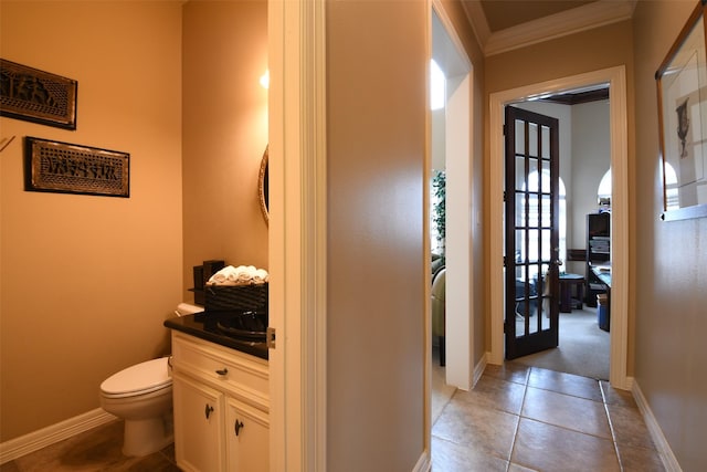 hall featuring crown molding, baseboards, light tile patterned flooring, and french doors