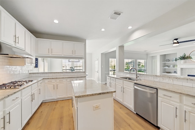 kitchen featuring a sink, visible vents, backsplash, under cabinet range hood, and appliances with stainless steel finishes