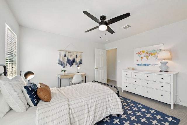 carpeted bedroom with baseboards, a ceiling fan, and visible vents