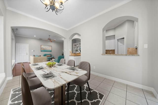 13611 Brookbluff Ln, Houston, TX 77077 - dining room featuring baseboards, arched walkways, light tile patterned floors, and crown molding