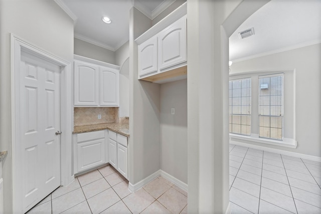 13611 Brookbluff Ln, Houston, TX 77077 - interior space featuring ornamental molding, light tile patterned floors, arched walkways, light stone countertops, and white cabinetry