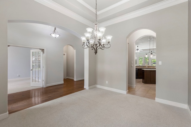 1614 Beau Rivage, Conroe, TX 77304 - spare room with arched walkways, light colored carpet, a chandelier, crown molding, and baseboards