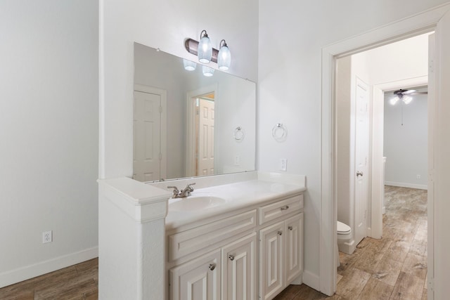 1614 Beau Rivage, Conroe, TX 77304 - bathroom featuring toilet, wood finished floors, vanity, ceiling fan, and baseboards