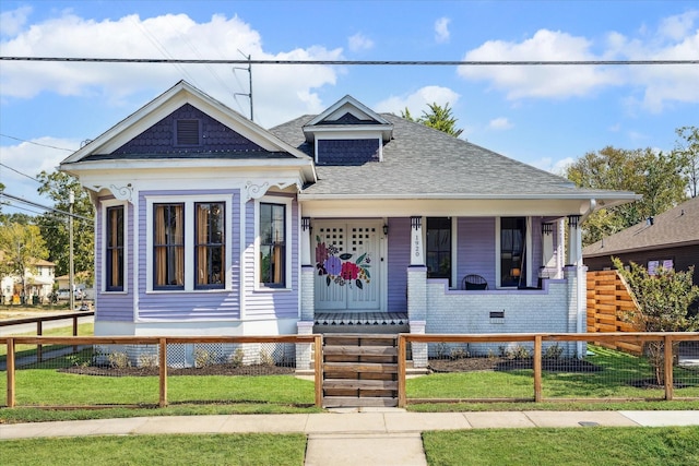 1920 Fulton St, Houston, TX 77009 - view of front facade with covered porch, roof with shingles, and a fenced front yard