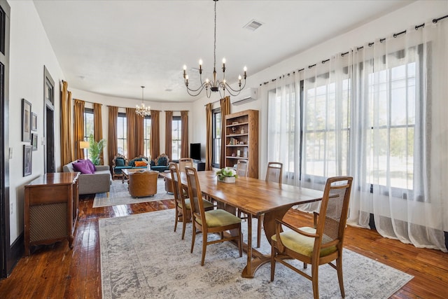 1920 Fulton St, Houston, TX 77009 - dining space featuring a chandelier, a wall unit AC, and wood-type flooring