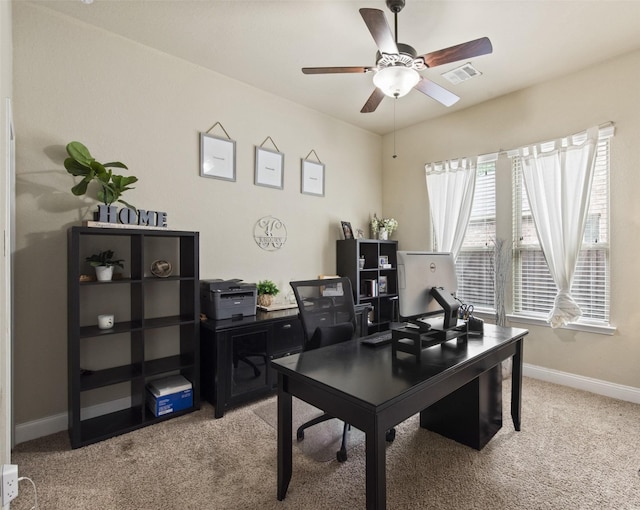 home office with baseboards, light carpet, a ceiling fan, and visible vents