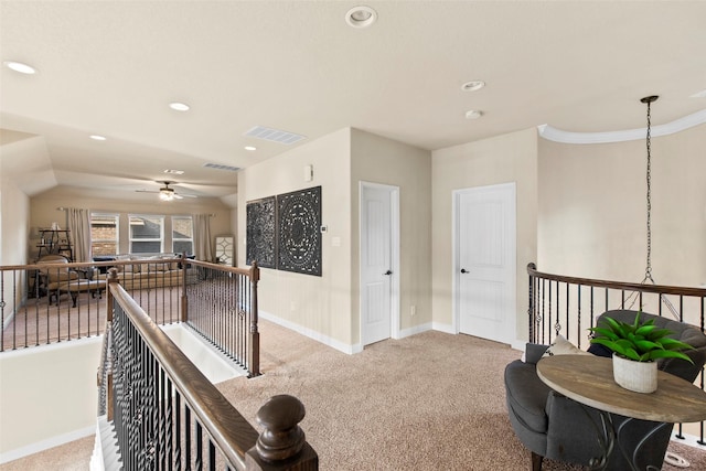 interior space featuring carpet floors, recessed lighting, baseboards, and an upstairs landing
