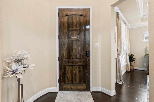entryway featuring baseboards, ornamental molding, and dark wood-type flooring