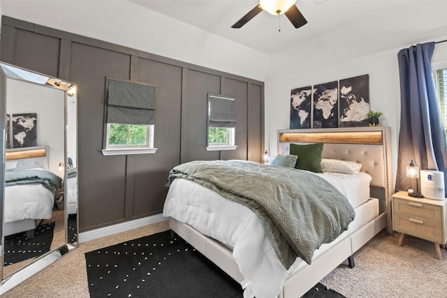 carpeted bedroom featuring multiple windows and ceiling fan