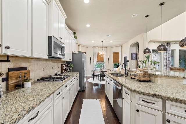 kitchen featuring decorative backsplash, recessed lighting, white cabinets, a sink, and stainless steel appliances