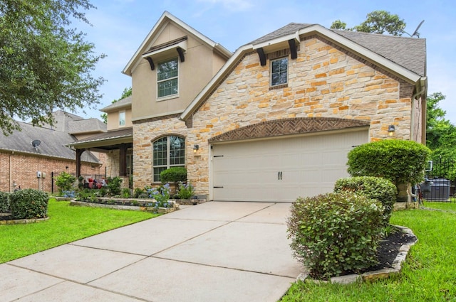 view of front of house with stucco siding, a front yard, driveway, and stone siding