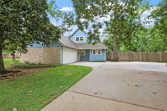 traditional home with driveway, an attached garage, fence, a front yard, and brick siding